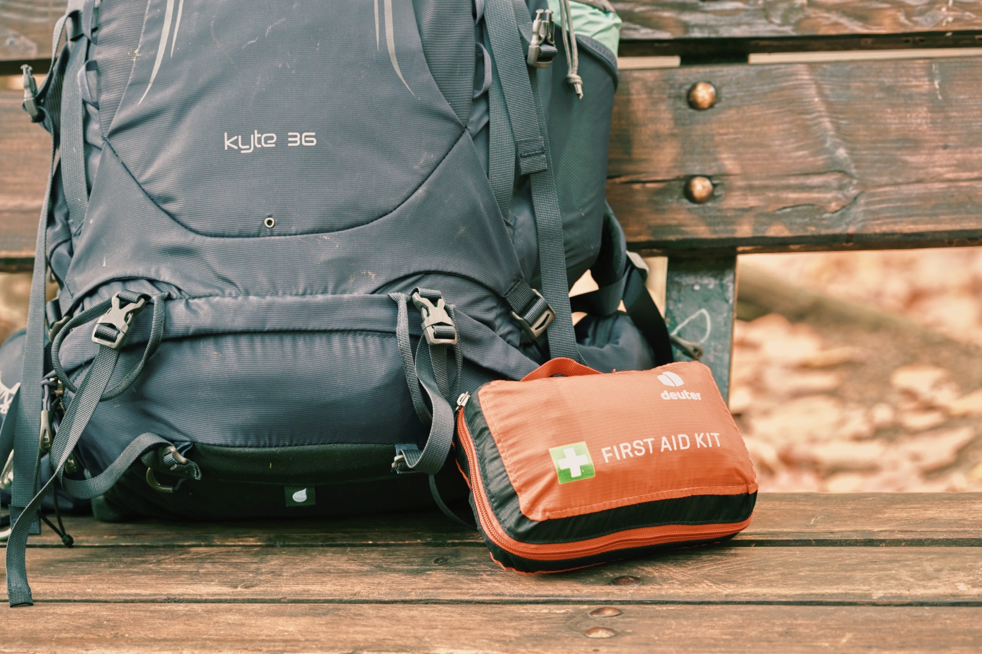 Hiking First Aid Kit and Osprey Hiking Backpack on a Bench While Hiking the Alpe Adria Trail